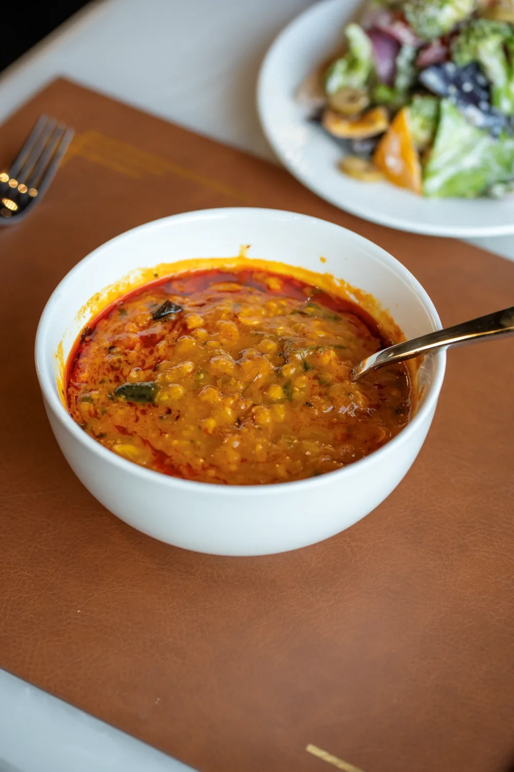 A bowl of home-style dal with a spoon